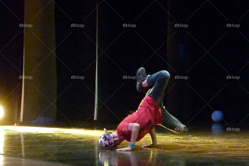 A young hip hop dancer makes a figure on the floor