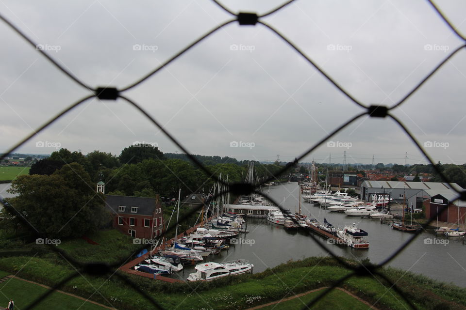 view of a European harbor with a grey sky in the summer.