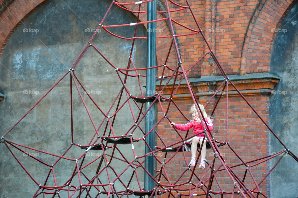 Alone little girl is playing at a playground in Copenhagen Denmark.