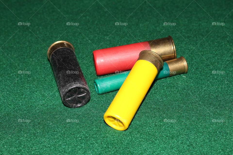 Shotgun shells. This is a photograph of shotgun shells on a green felt table.