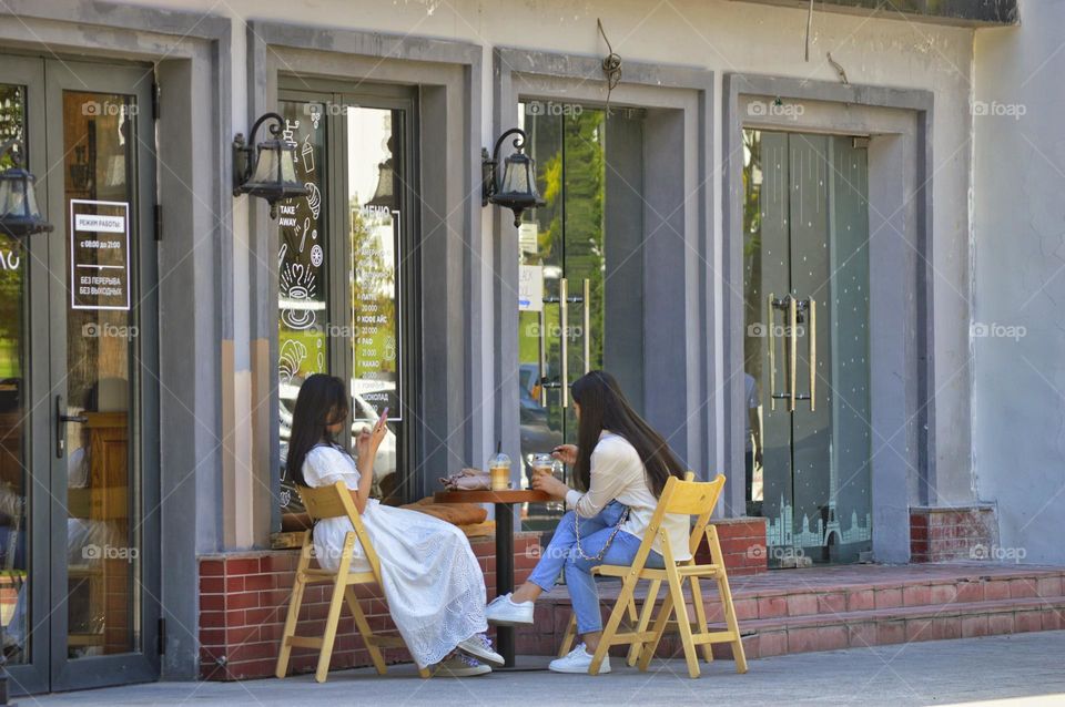 two friends having breakfast in a street cafe