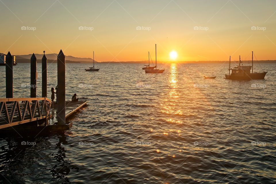 Silhouetted sailboats during sunset