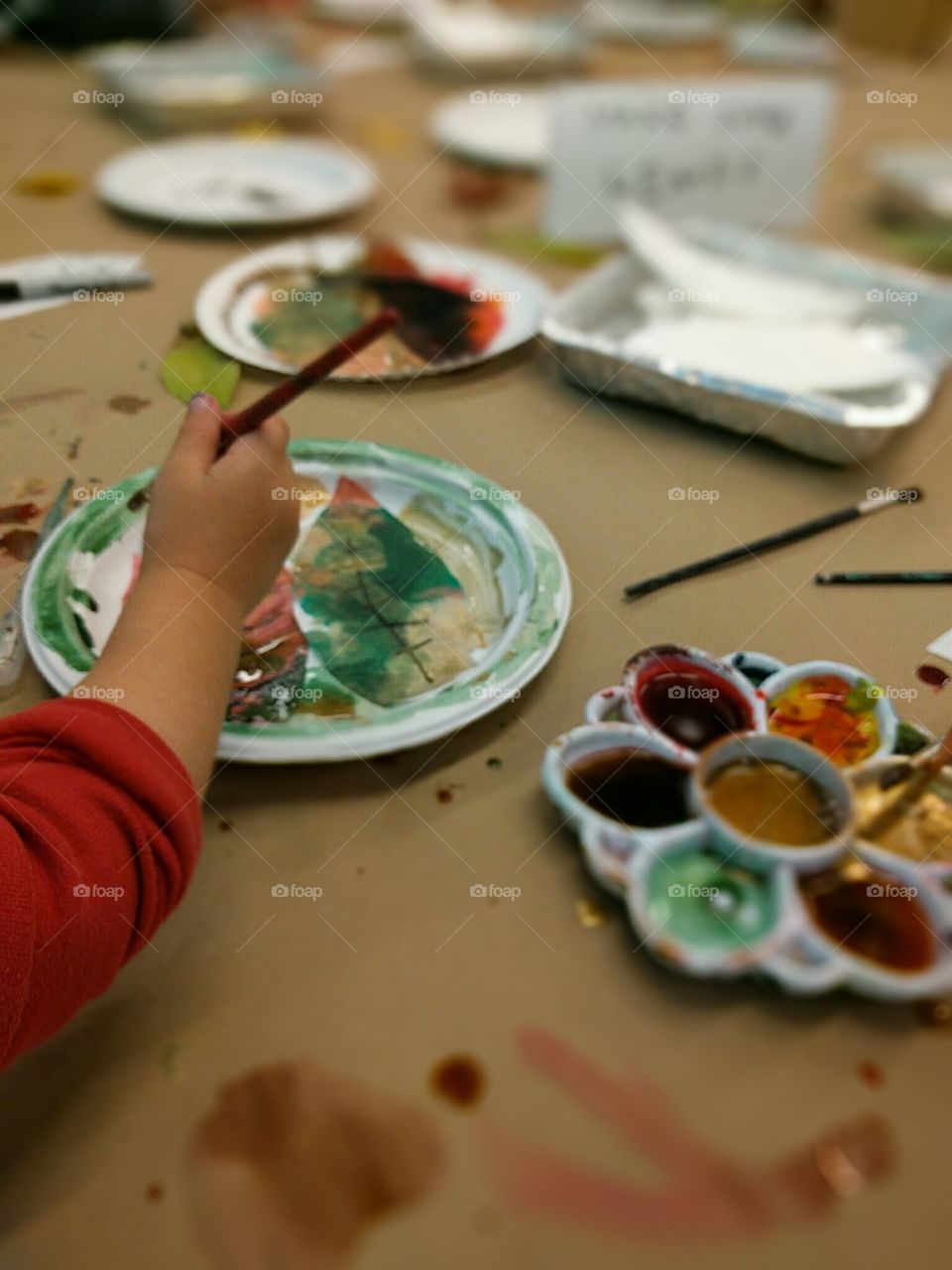 A small child adds detail to her leaves