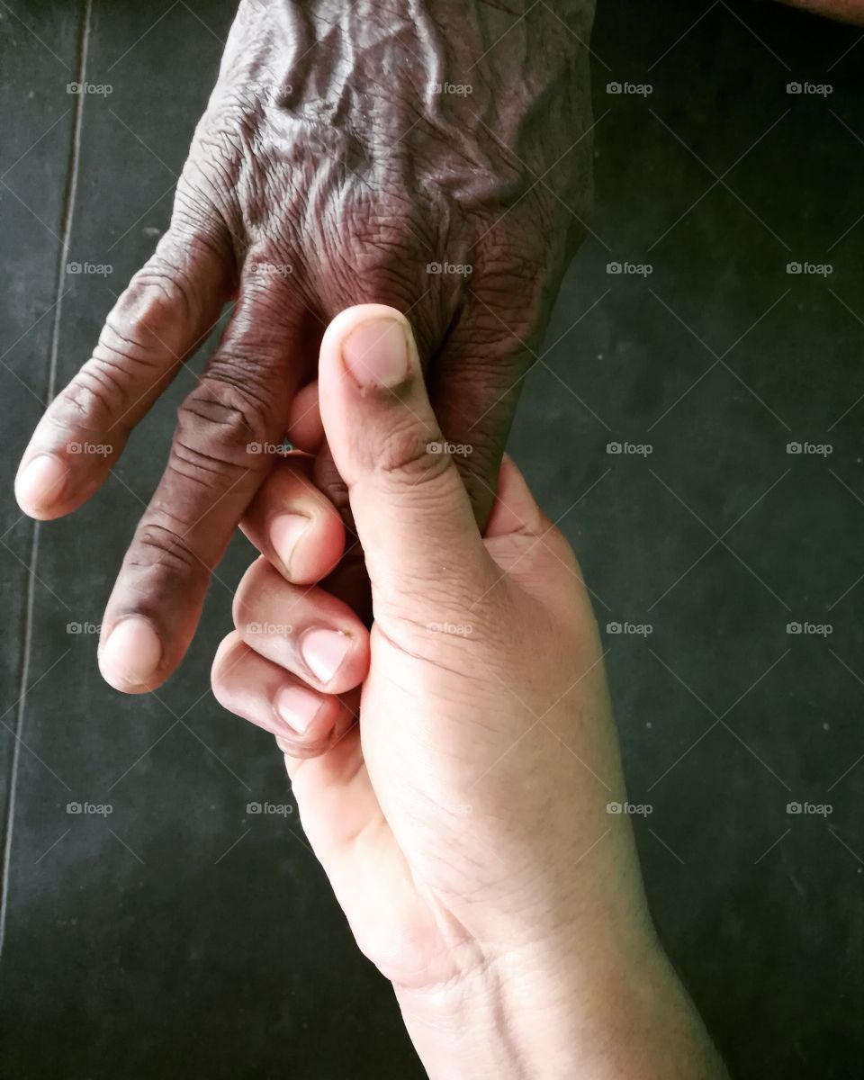Close-up of grandmother and granddaughter holding hands