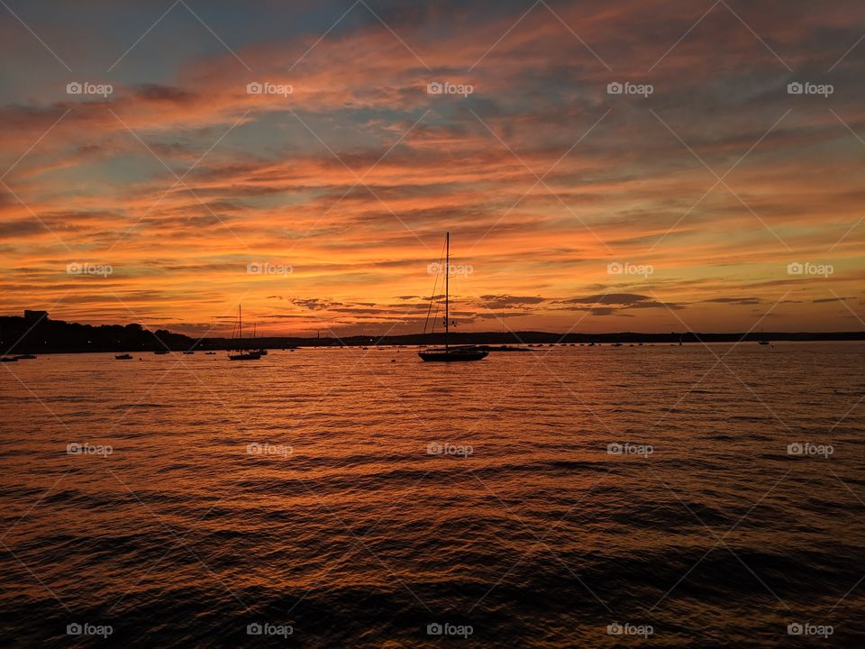 sunset on the ocean; calm water; landscape