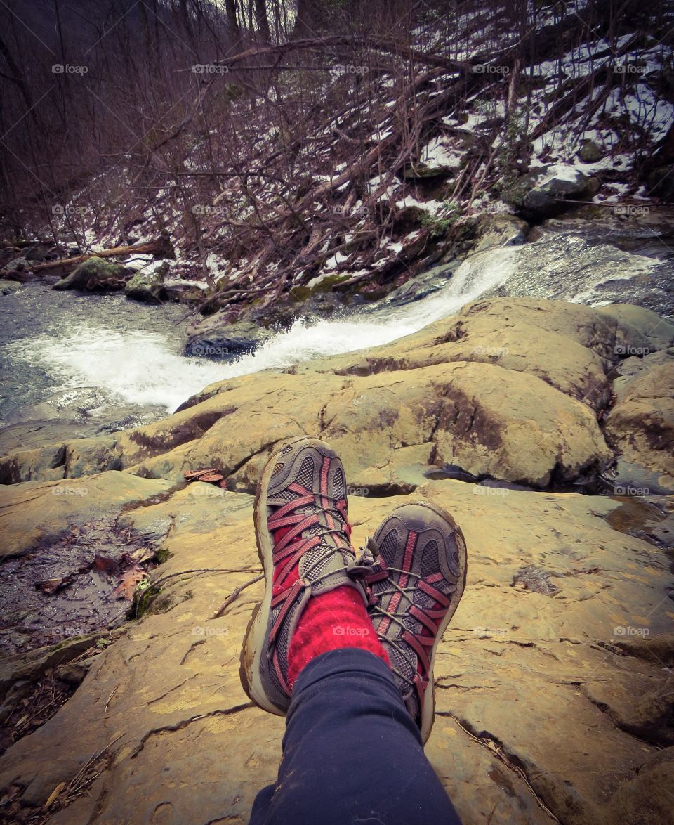 Low section of person sitting on rock