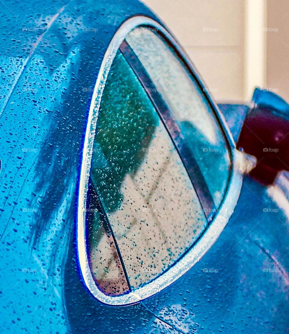 Curved sports car window just after the rain.