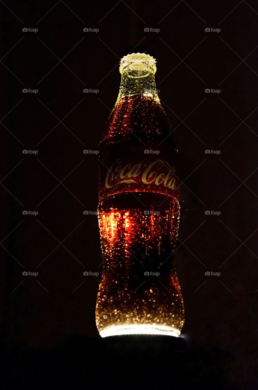 Coca-Cola bottle close up. Black background.