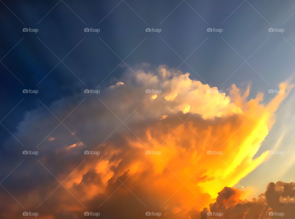 Beautiful red and gold sunset inside of billowing clouds and sun rays.