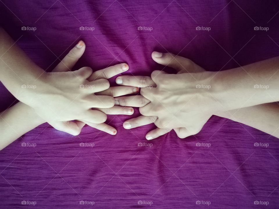 Close-up of holding hands against purple background