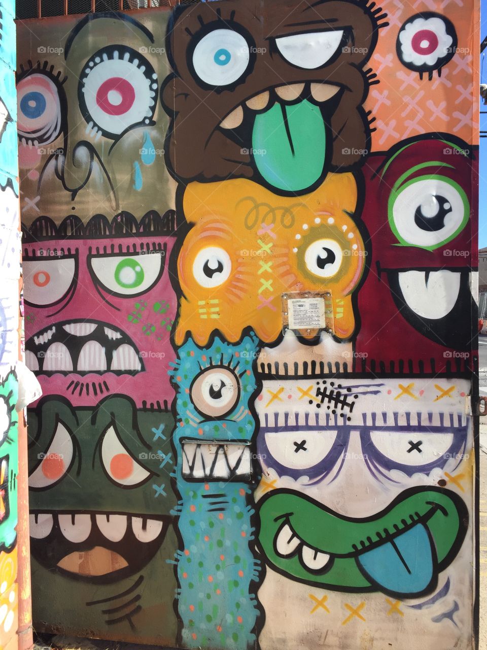 This is a picture of urban graffiti in Brooklyn . The picture depicts extraterrestrial faces with different emotions. The artwork is done uniquely with extreme detail. Looking upon the faces you have a retro feel.