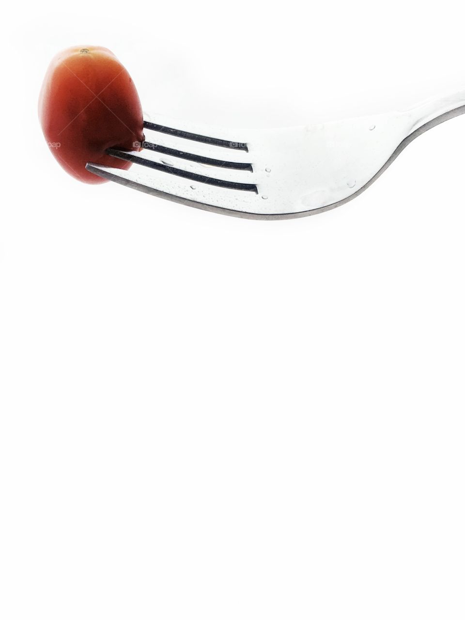 Plum tomato on metal fork