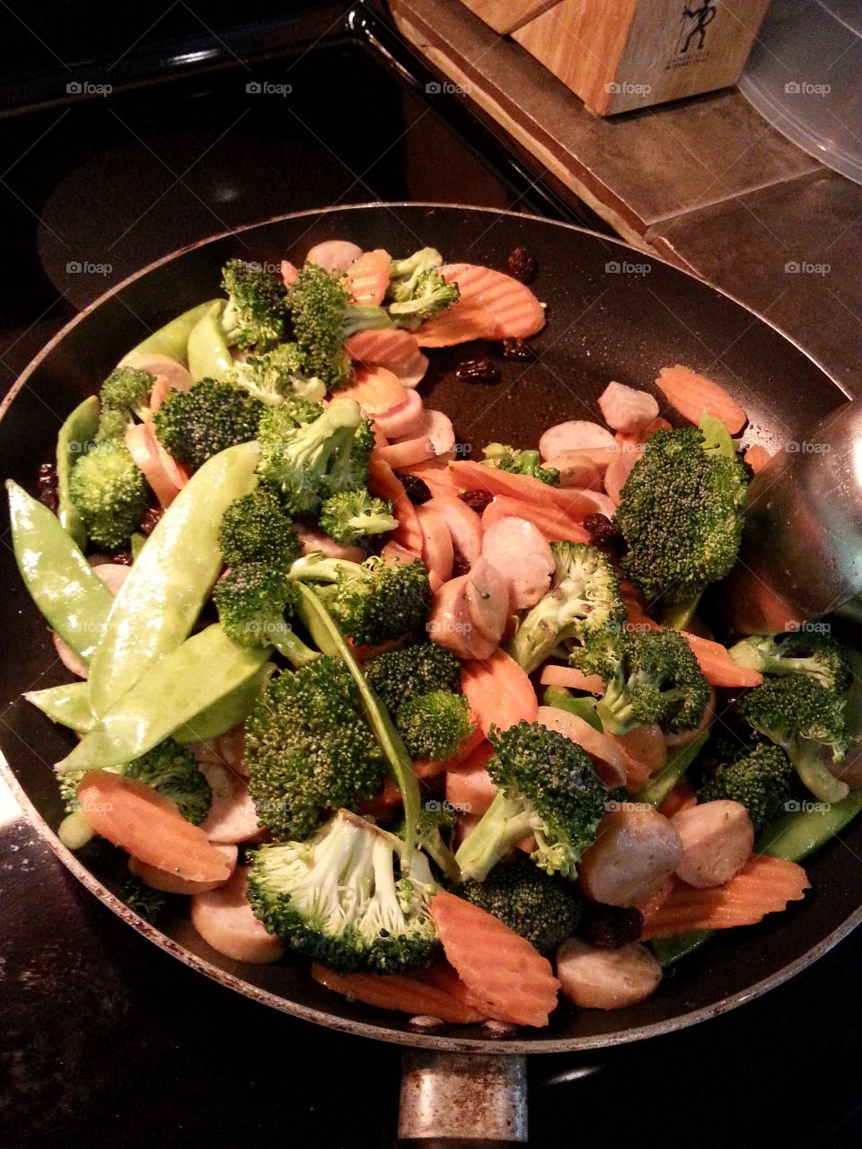 Chicken sausage,  broccoli,  snap peas,  raisins, and carrots