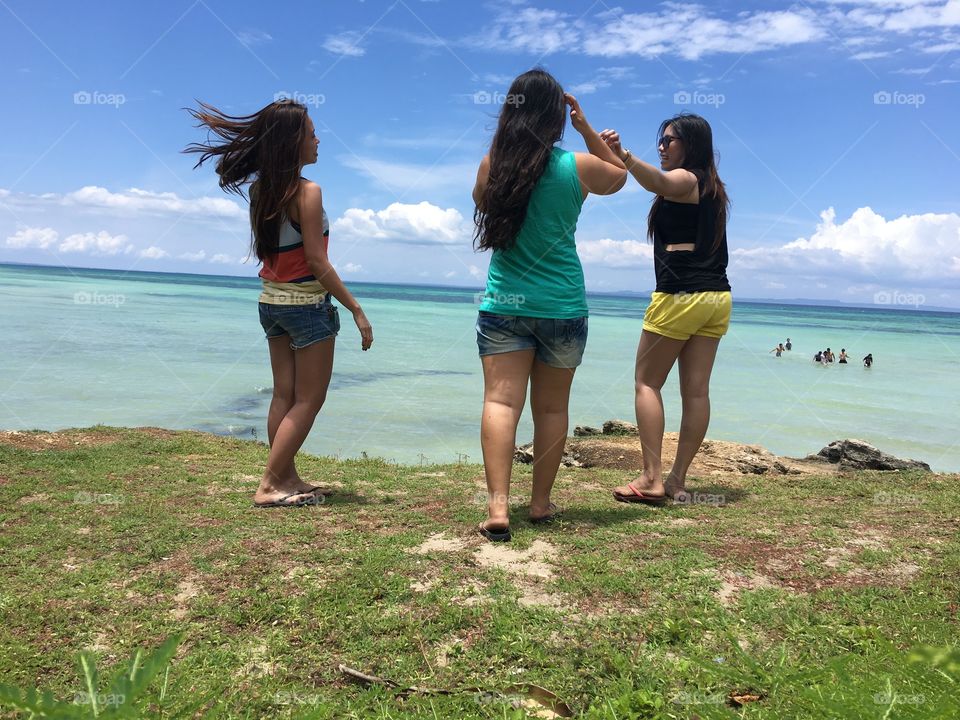 Girls walking together overlooking the beautiful scenery of white beach. Enjoying the nice breeze and freshness of the air.