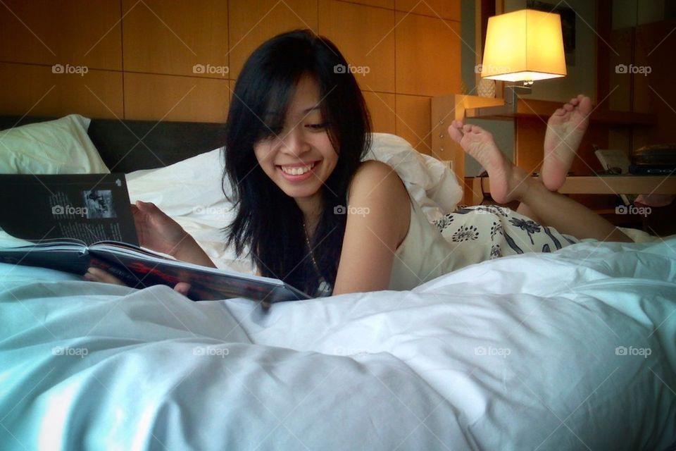 Girl reading a book on the bed