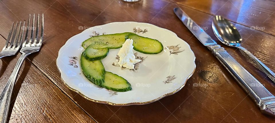 cucumbers and whipped feta cheese as the final course of dinner on a fancy plate