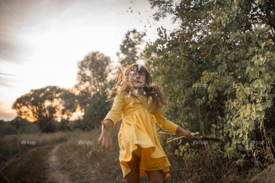 Little girl in yellow dress outdoor portrait at sunset 