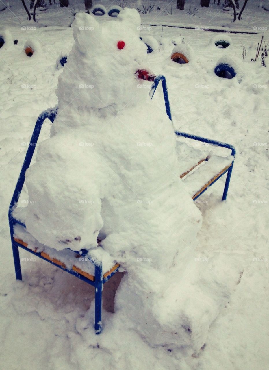 Snowman sitting on bench