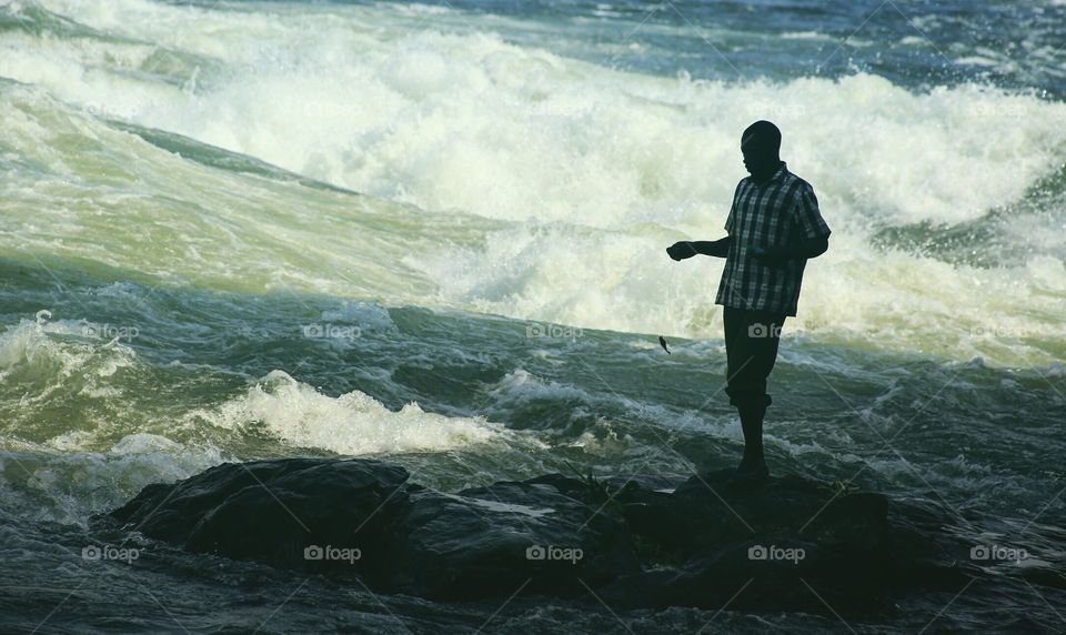 A man fishing at the Nile River.