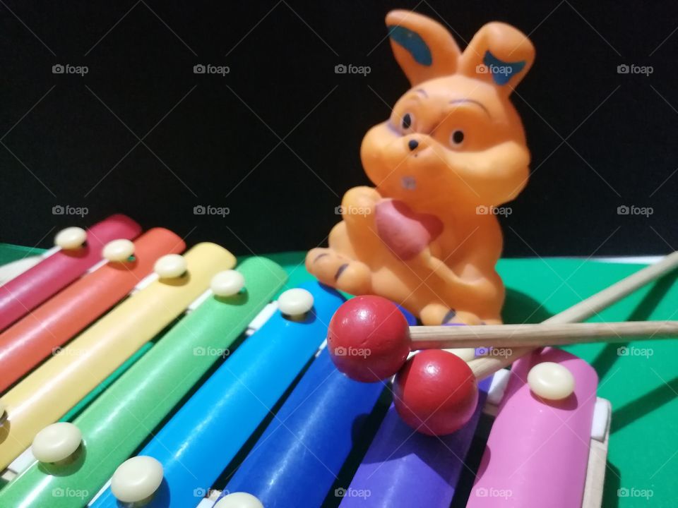 Colorful xylophone, stick and toy rabbit.