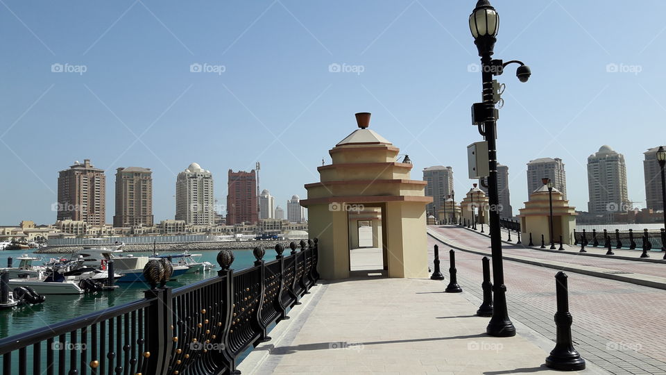 Walkway by the bridge/ Surrounded by luxury hotels and boats/ Ocean view/ Beautiful sunshine day