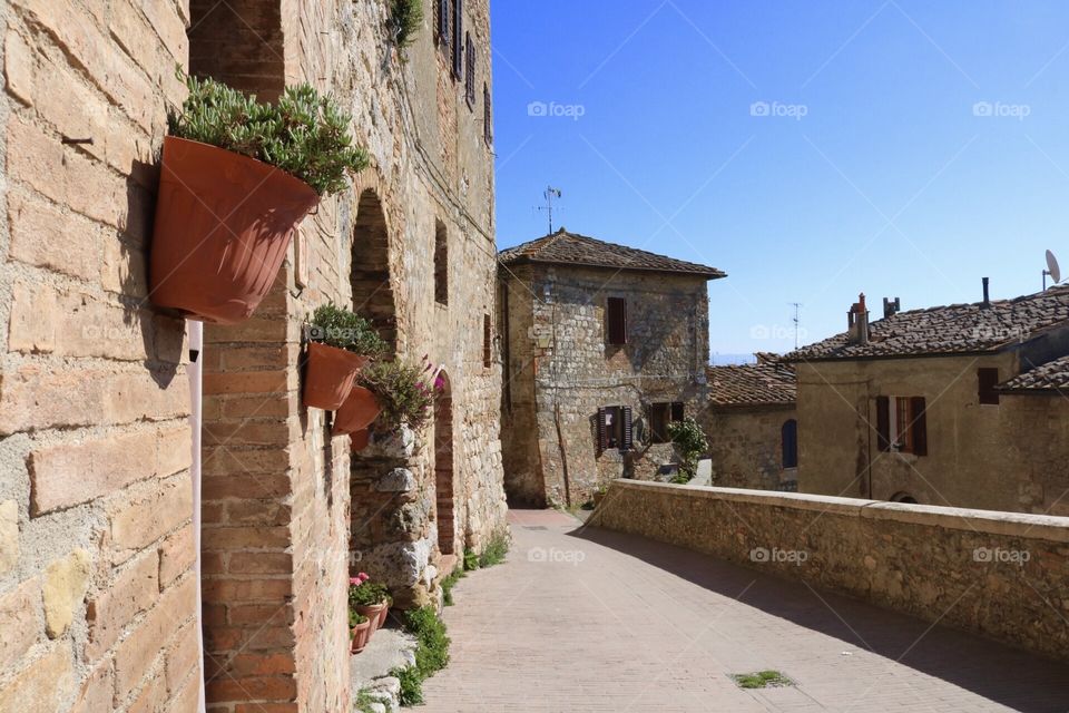 Toscana pitoresca com seus vasos de plantas e seus tijolos em um lindo dia de céu azul.