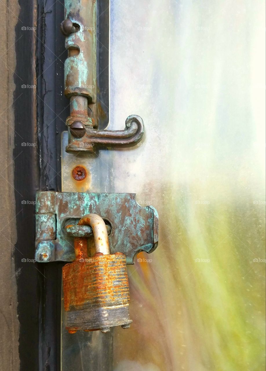 Rusty iron lock on door hinge