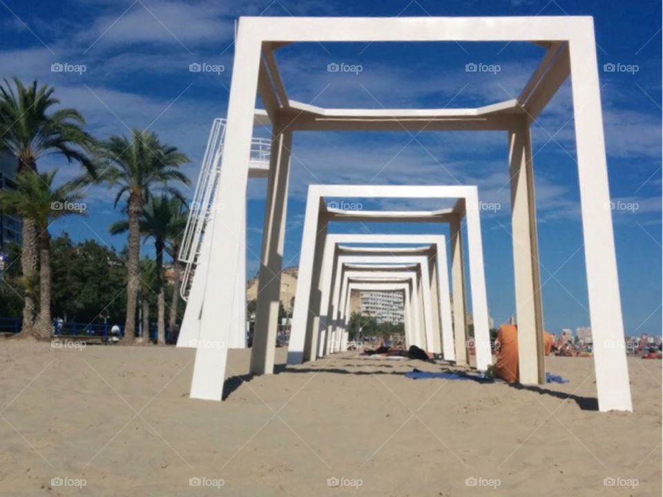 Geometric wooden frame structure sitting on a tropical beach in Alicante, Spain