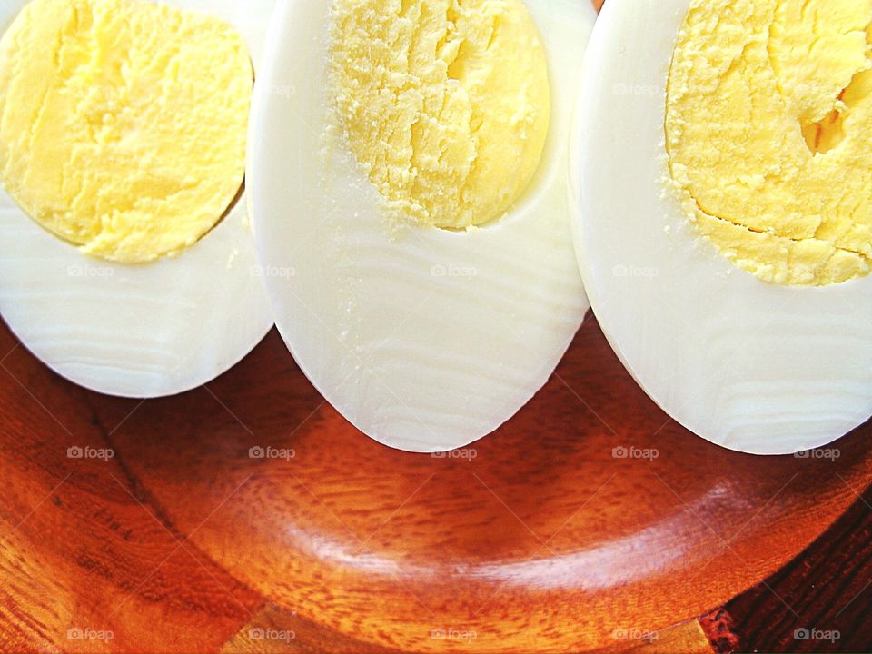 Closeup of cut hard boiled eggs in wooden bowl 