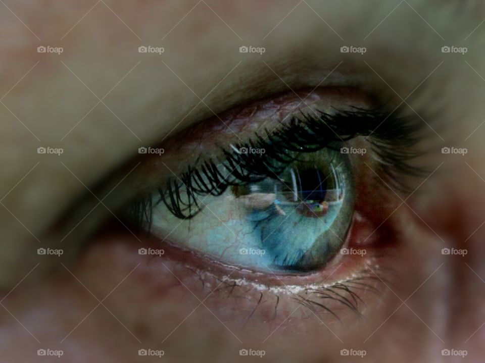 Reflection of swimming pool in closeup of an eye