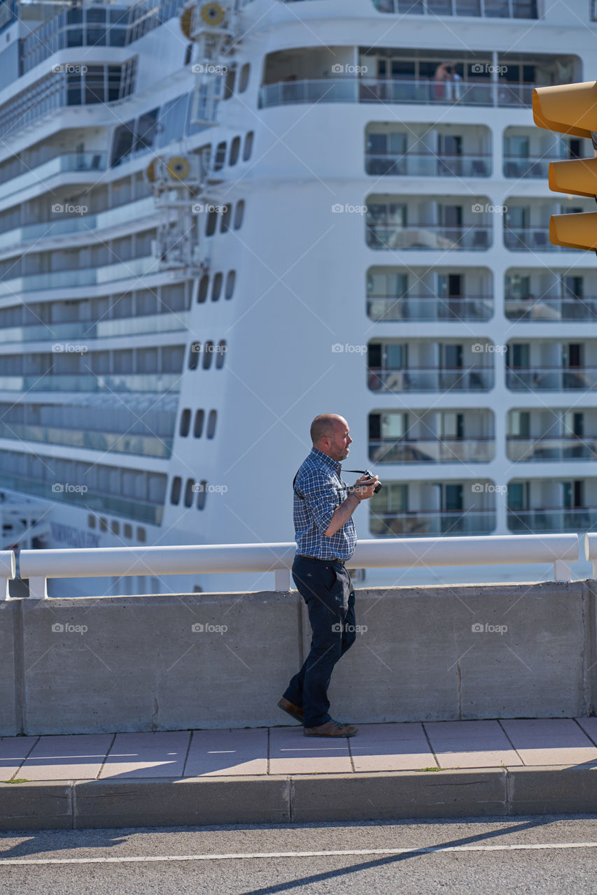 Man standing in front of modern building holding camera