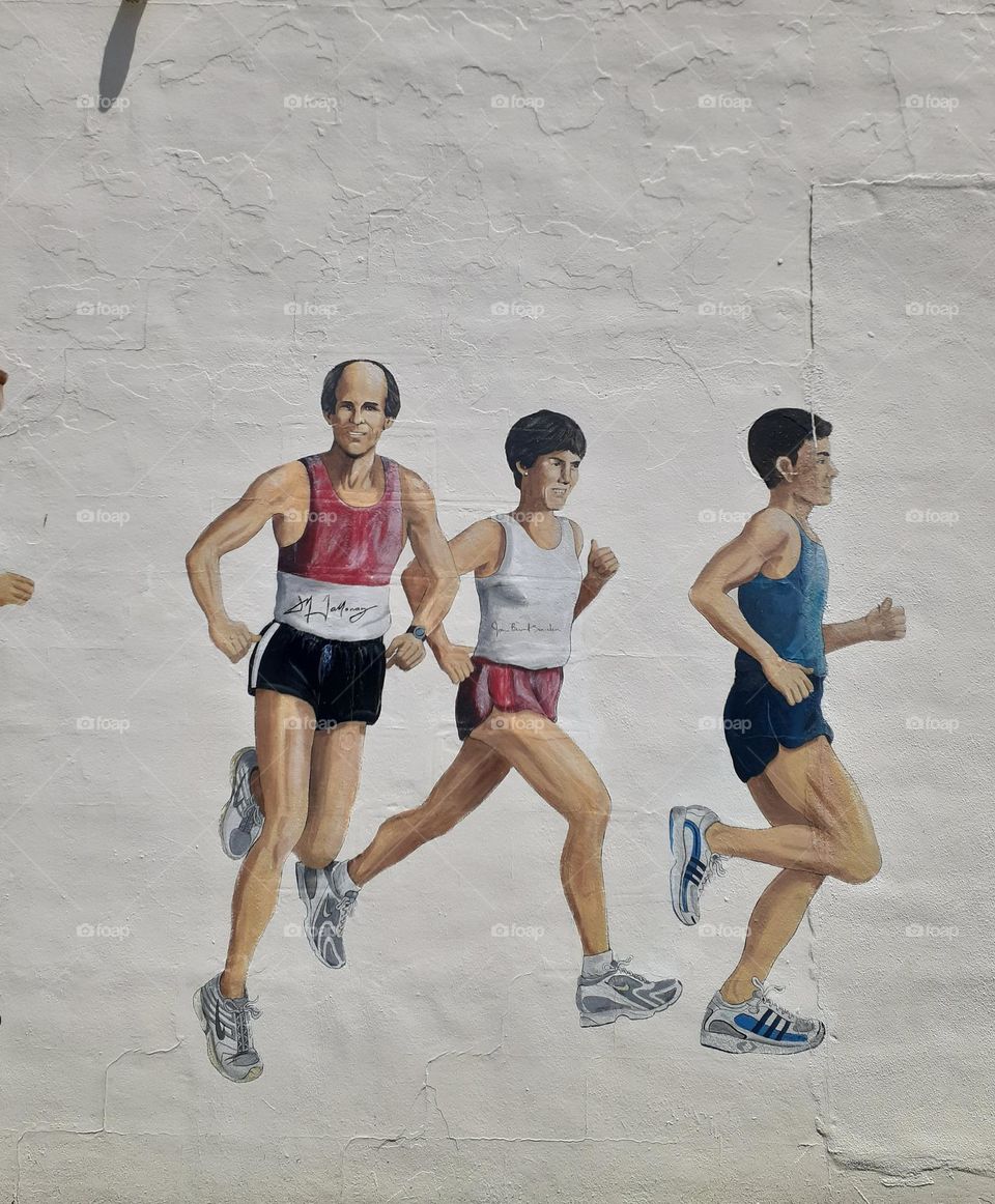 A mural depicting runners running on the side of a track store off Mills Avenue in downtown Orlando, Florida.