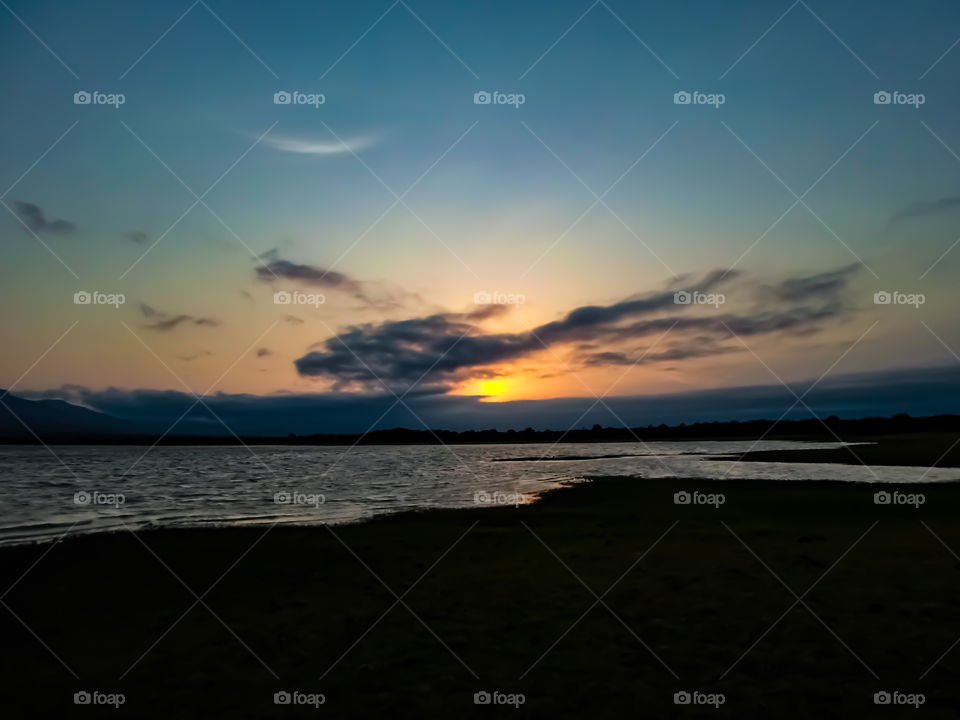 sunset behind clouds on a lake
