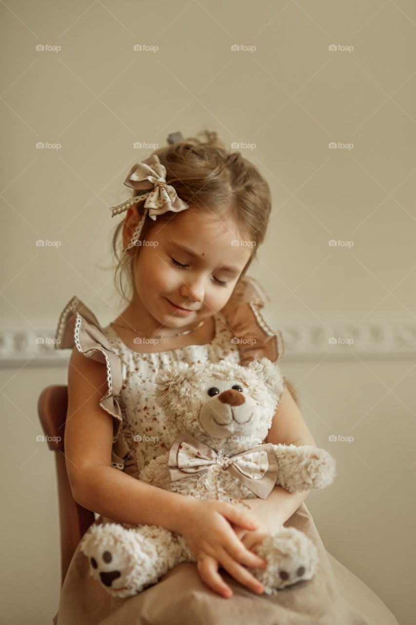 Vintage portrait of a beautiful little girl with teddy bear 