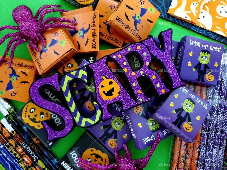 Halloween flat lay with bright green background with the word scary and kids treats and goodies