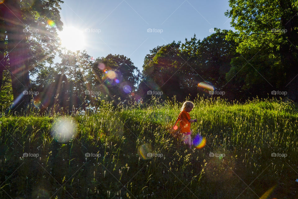 Little girl of three years old playing in the grass at stadsparken in Lund Sweden.