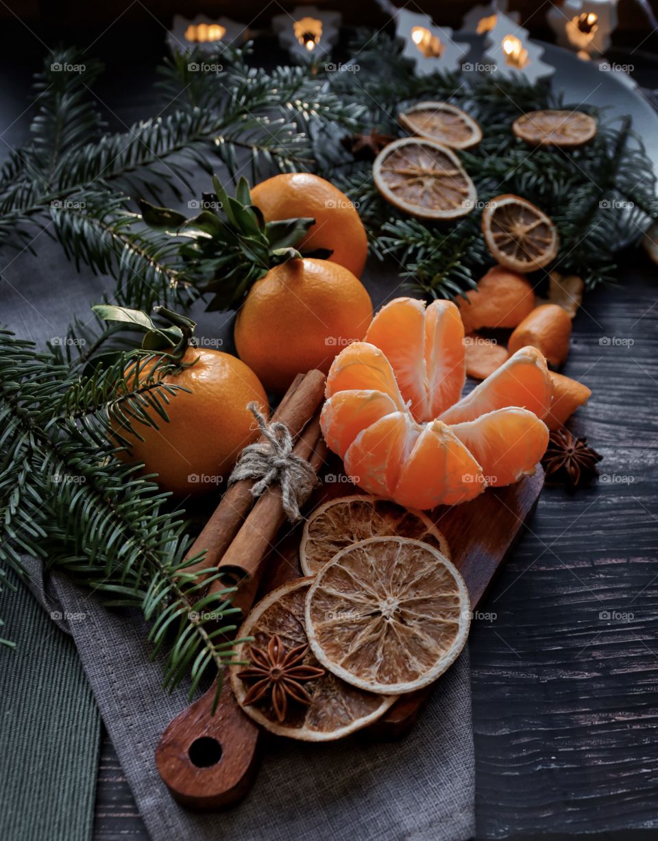 Flatlay mandarin orange cinnamon and Christmas tree branches 