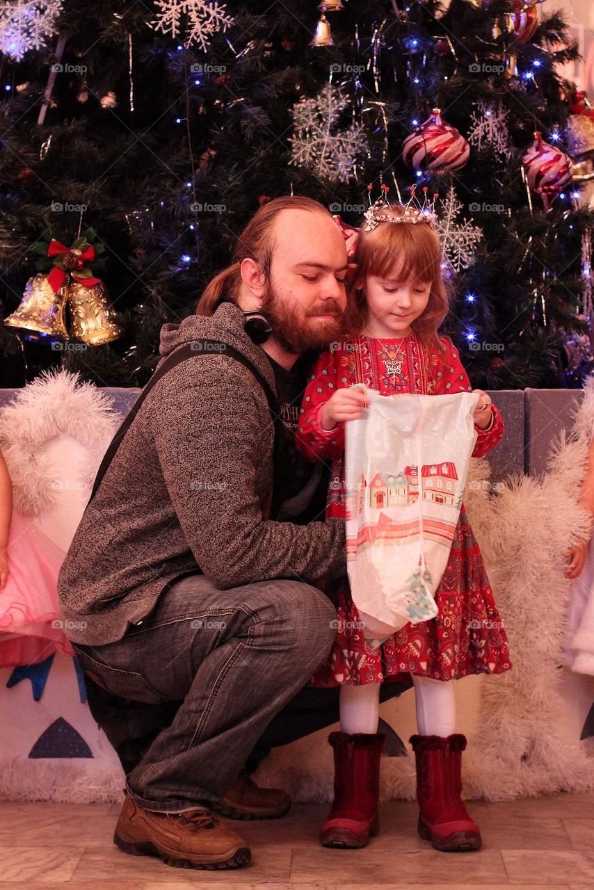 A couple with their daughter look at what Santa Claus gave