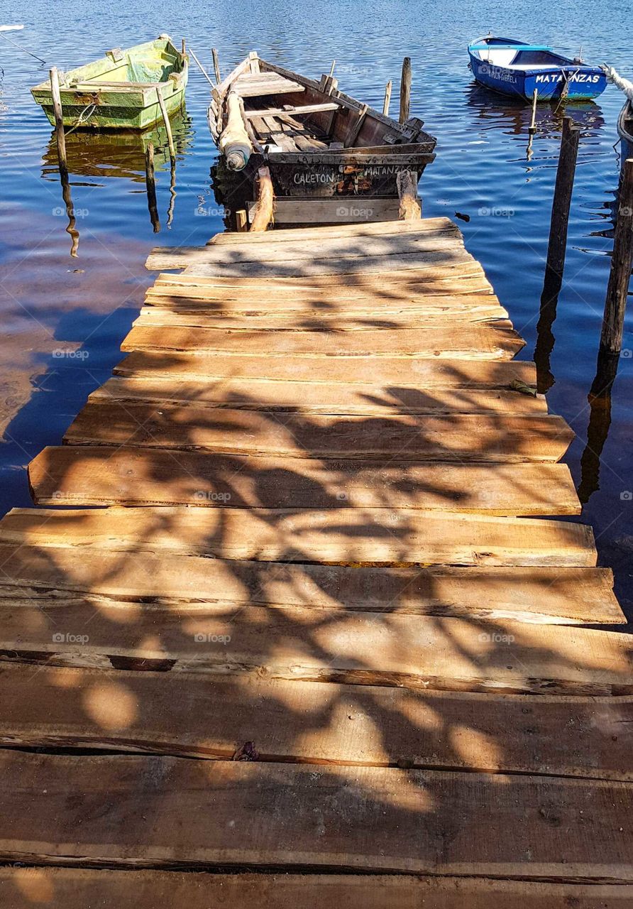 Boats at a small jetty in the shimmering sunlight