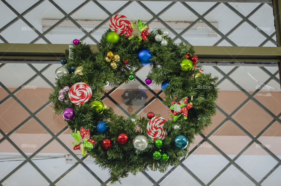 A Christmas Wreath Hanging On A Metal Grill
