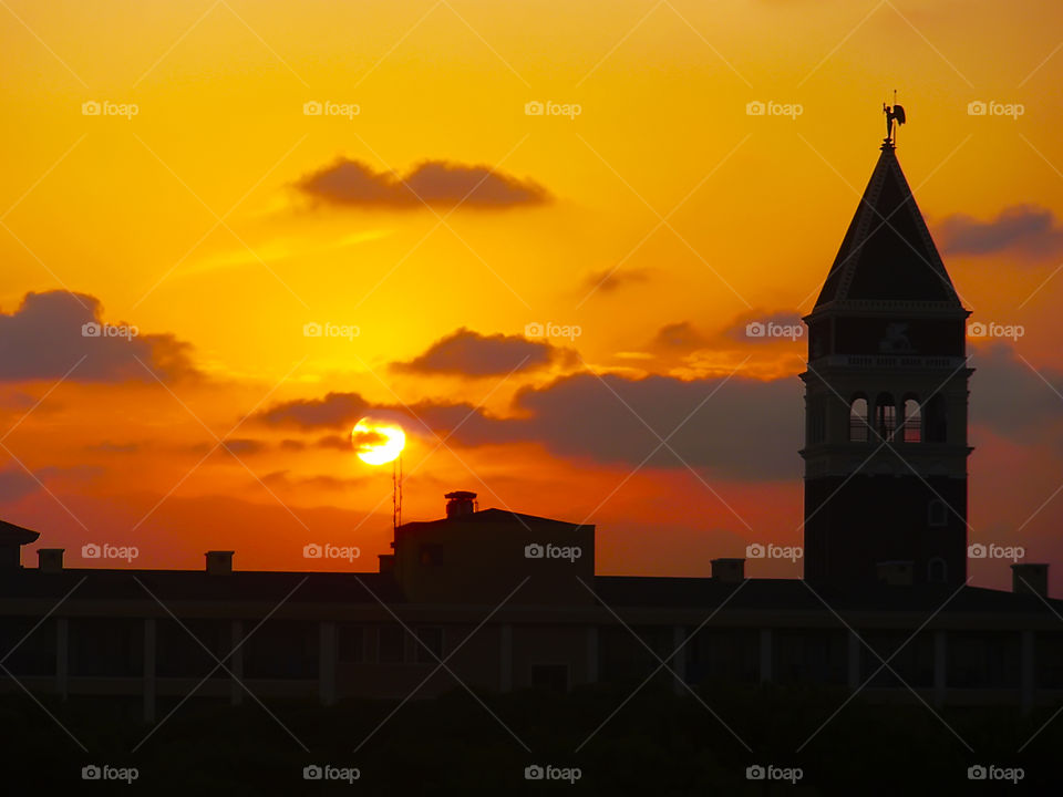 Sunset over the silhouette of the old tower 