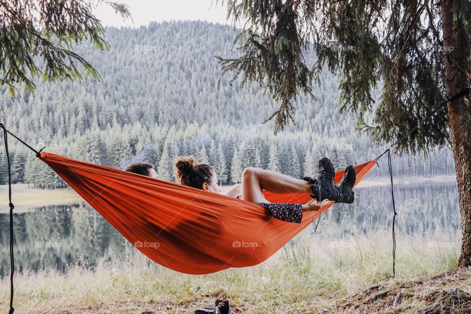 couple sitting in a hammok admiring the view