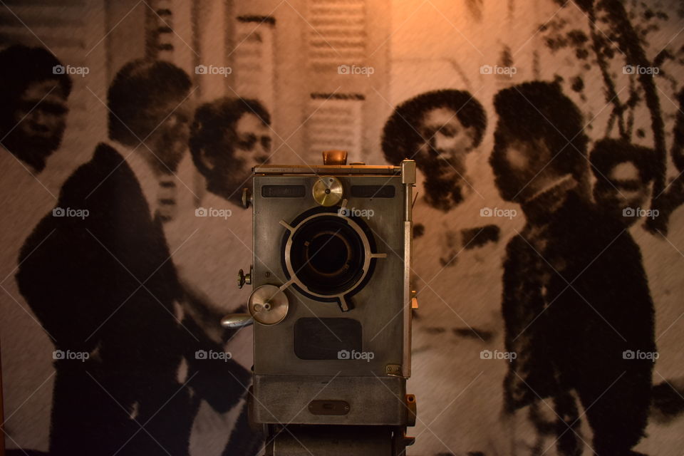 Antique movie camera with unidentified ancient people picture background