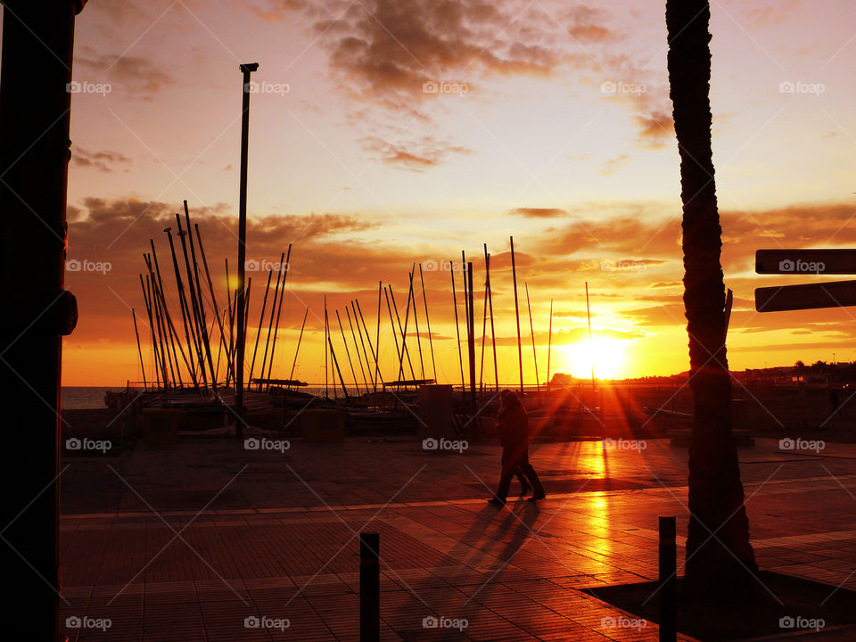 People walking near beach at sunset