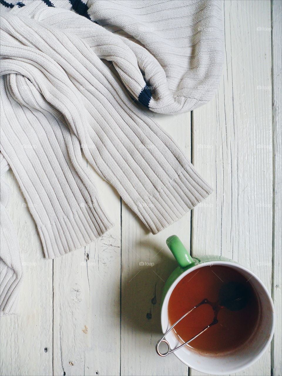 A cup of black tea and a white sweater