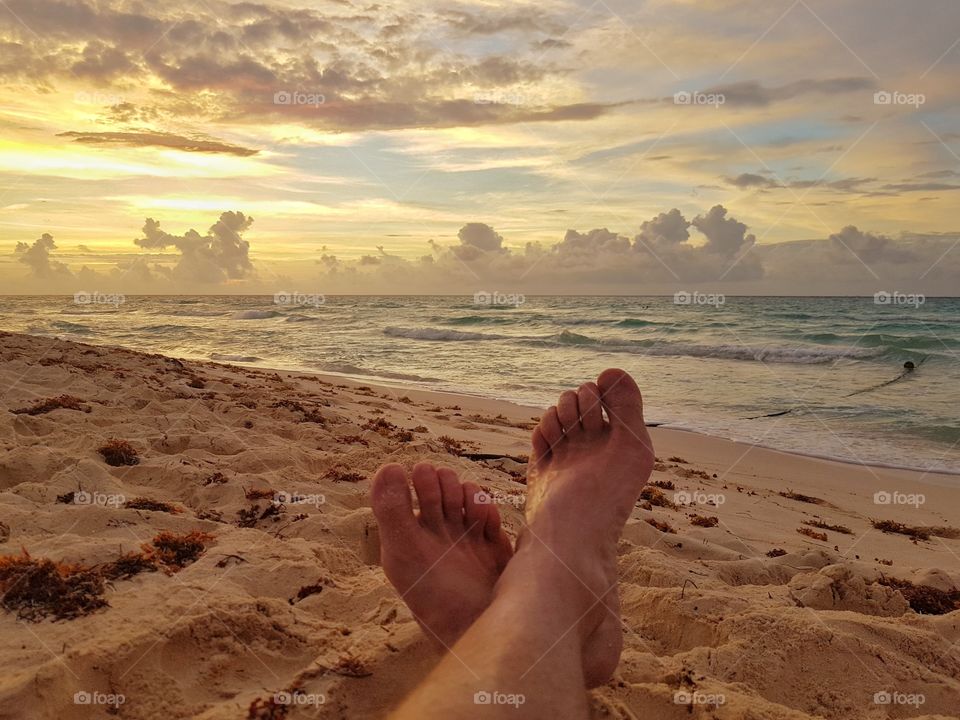 resting with extended legs in the beach at sunrise