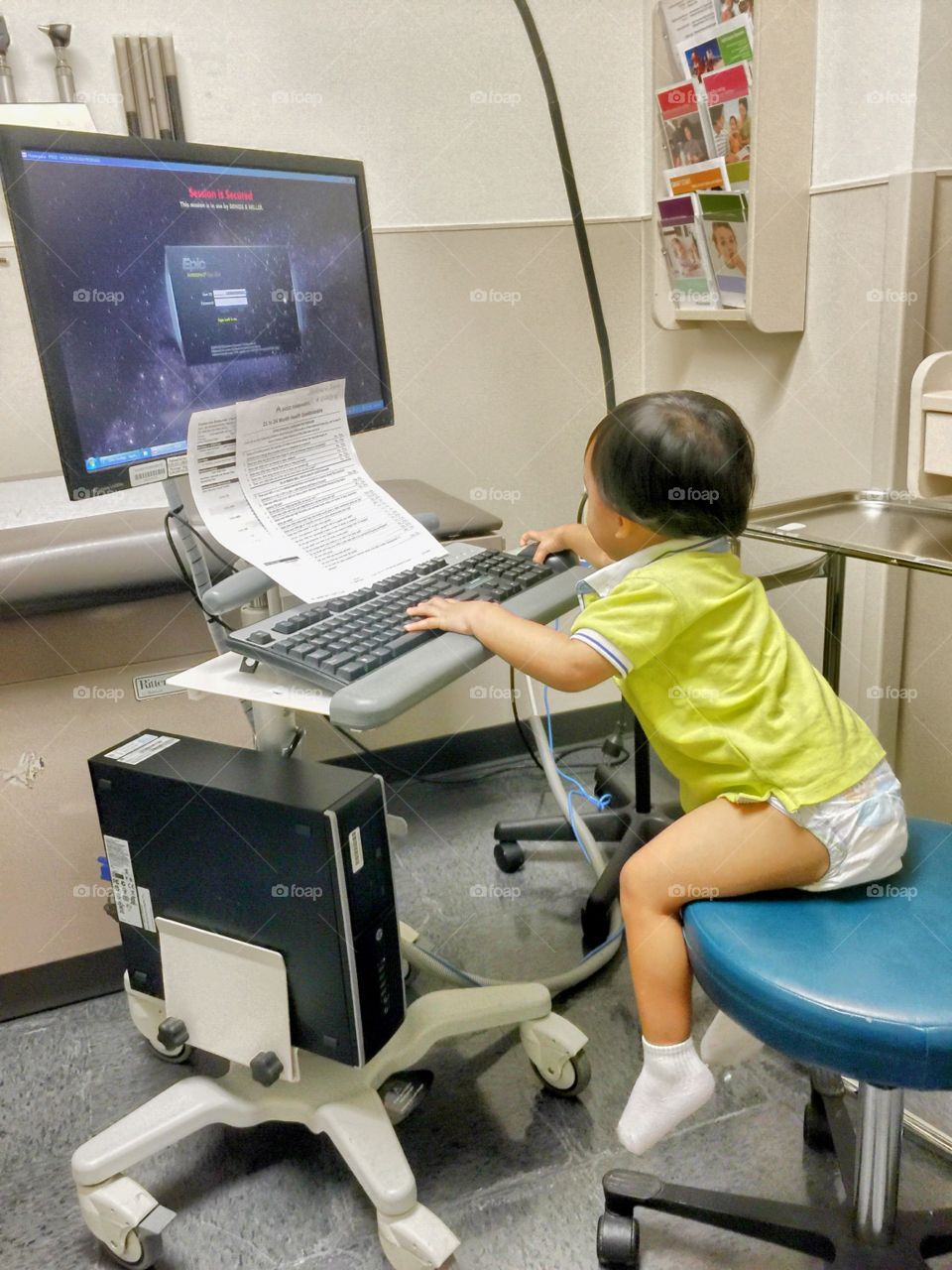 Baby and computer. Visiting the yearly checkup from his doctor. 
