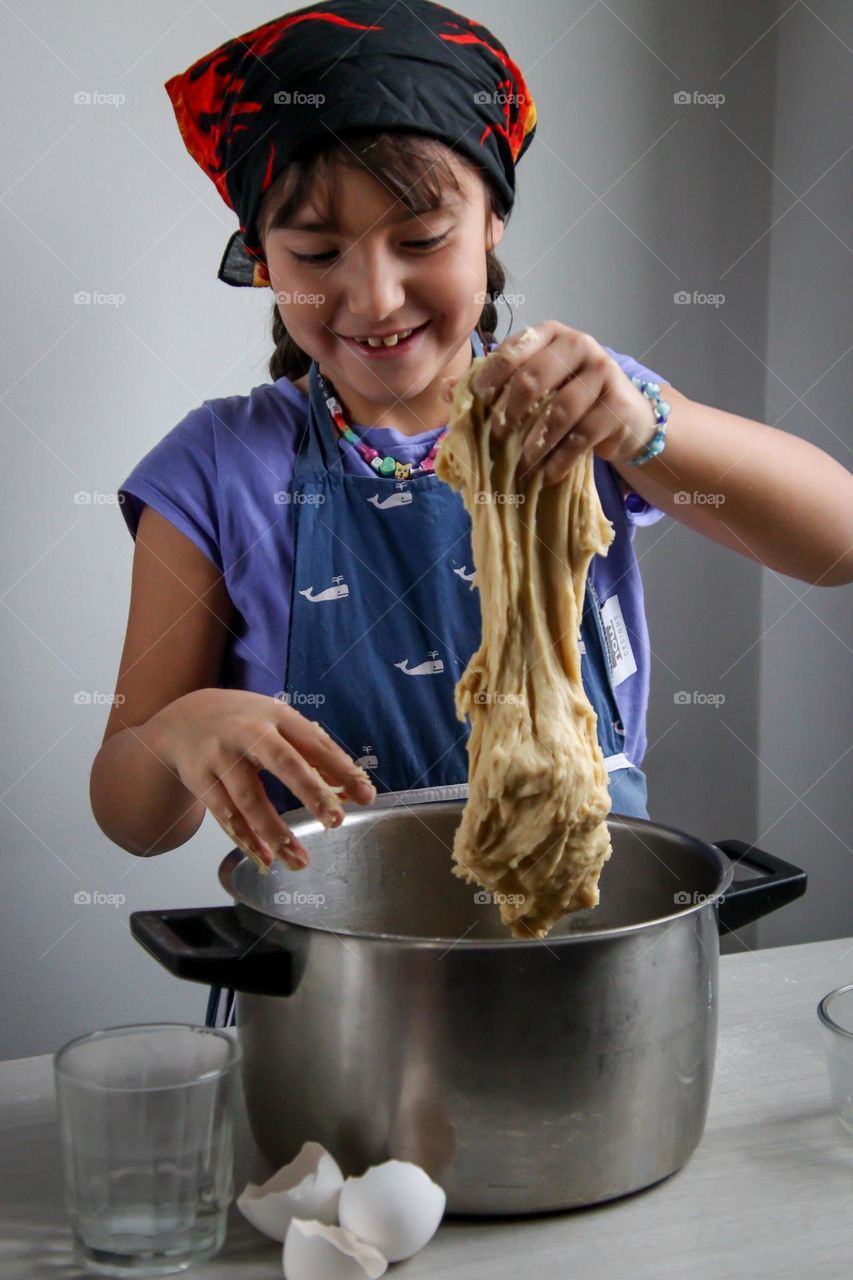 Cute little girl is helping with a bread dough