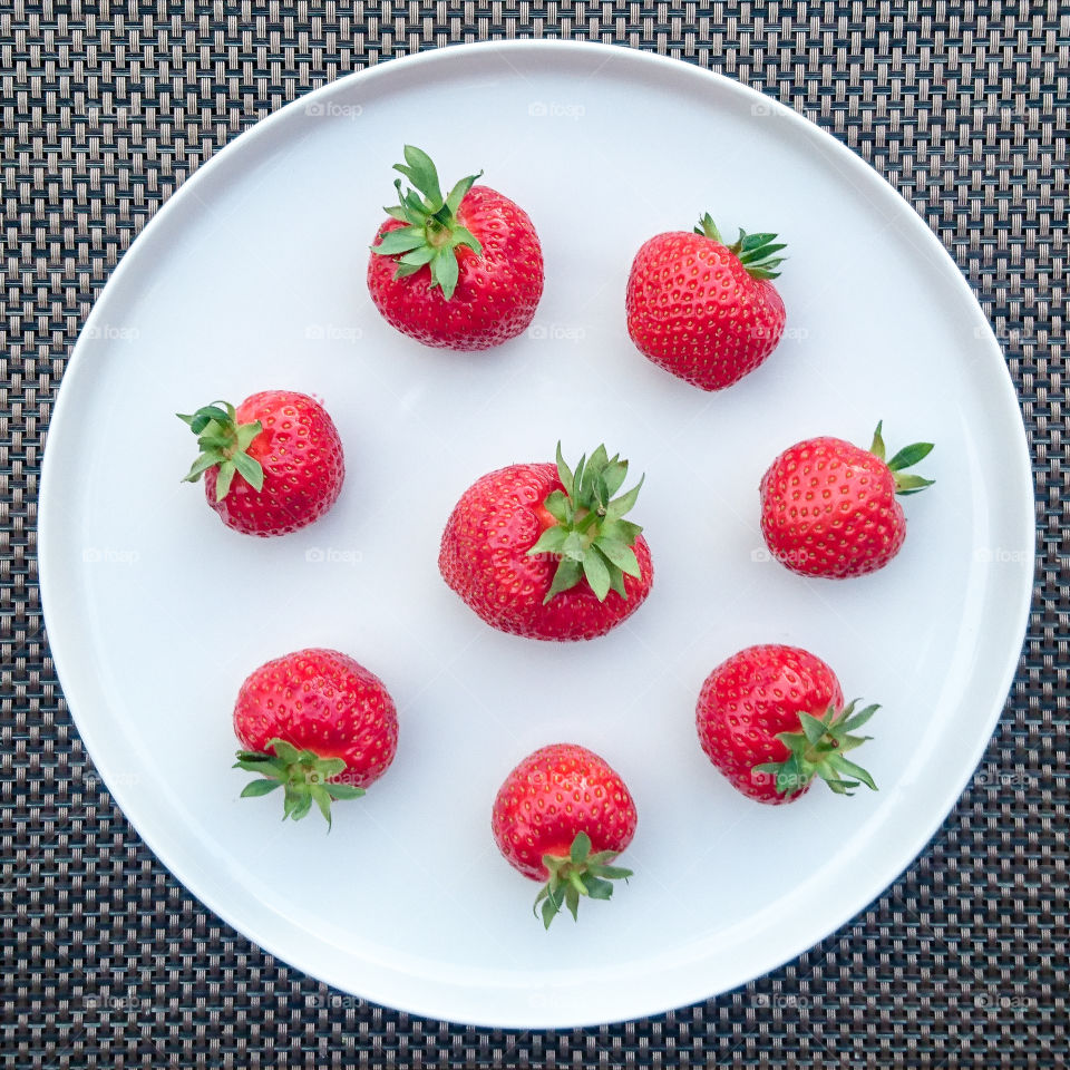 plate with fresh red strawberries