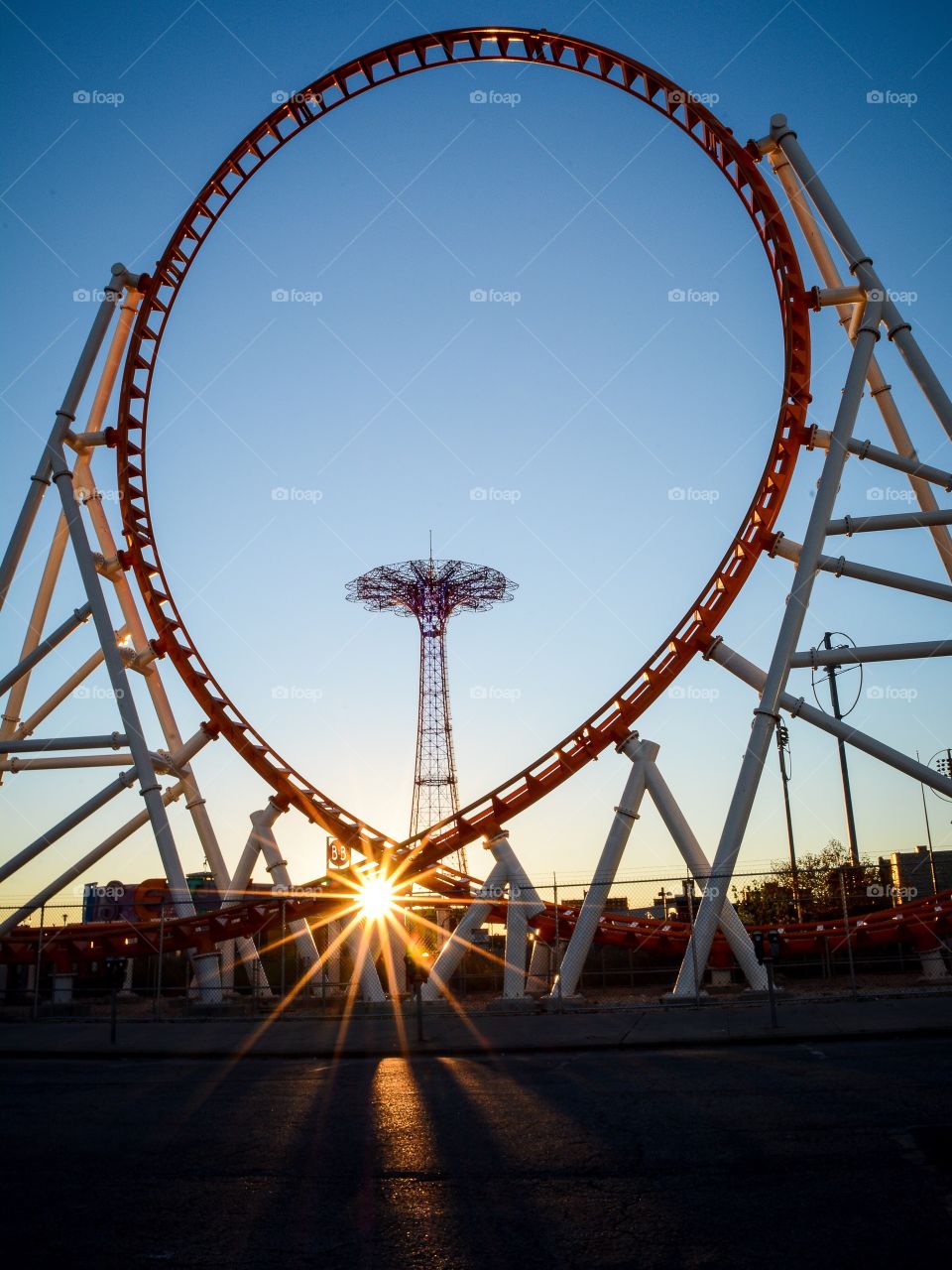 Parachute jump seen through Thunderbolt ride with some sun flares in Coney Island